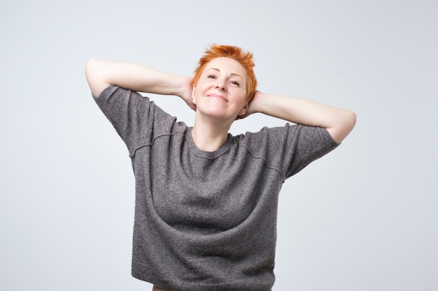 Mujer pelirroja madura en una blusa gris