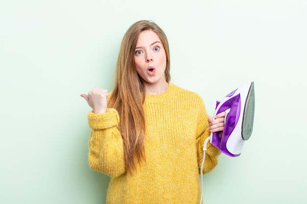 Mujer pelirroja mirando asombrada con incredulidad. concepto de ropa de hierro