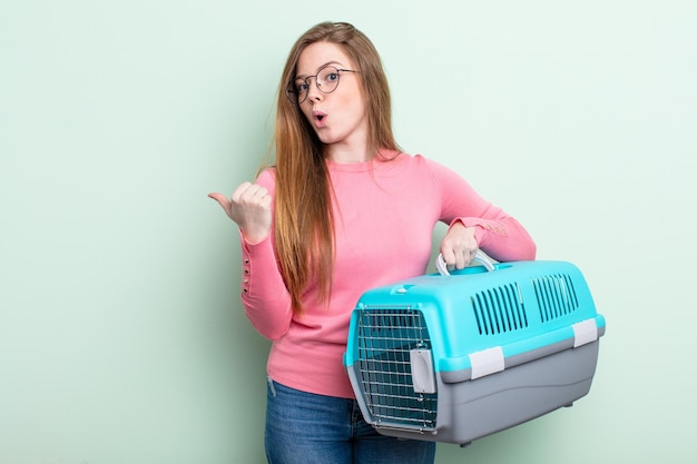 Foto mujer pelirroja mirando asombrada con incredulidad concepto de transporte de mascotas de viaje