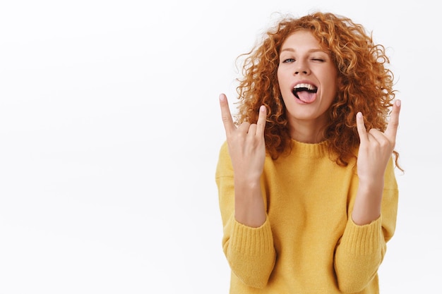 mujer pelirroja con pelo rizado fiesta toda la noche, mostrando rock-n-roll