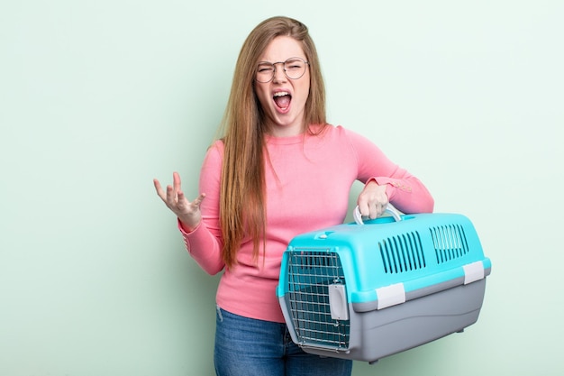 Mujer pelirroja que parece enojada, molesta y frustrada, concepto de transporte de mascotas de viaje