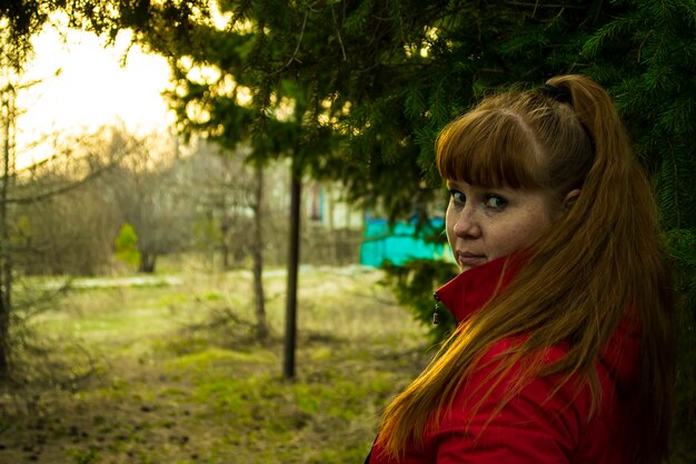 Mujer pelirroja respira aire limpio en la naturaleza bosque fresco parque al aire libre concepto de estilo de vida saludable