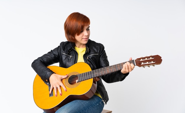 Mujer pelirroja tocando la guitarra