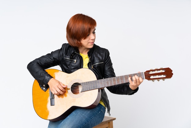 Mujer pelirroja tocando la guitarra