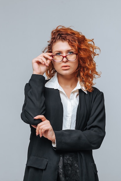 Mujer pelirroja en traje y toca gafas