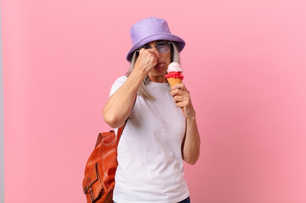 Mujer de pelo blanco de mediana edad con un helado. concepto de verano