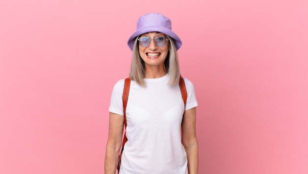 Mujer de pelo blanco de mediana edad que parece feliz y gratamente sorprendida. concepto de verano