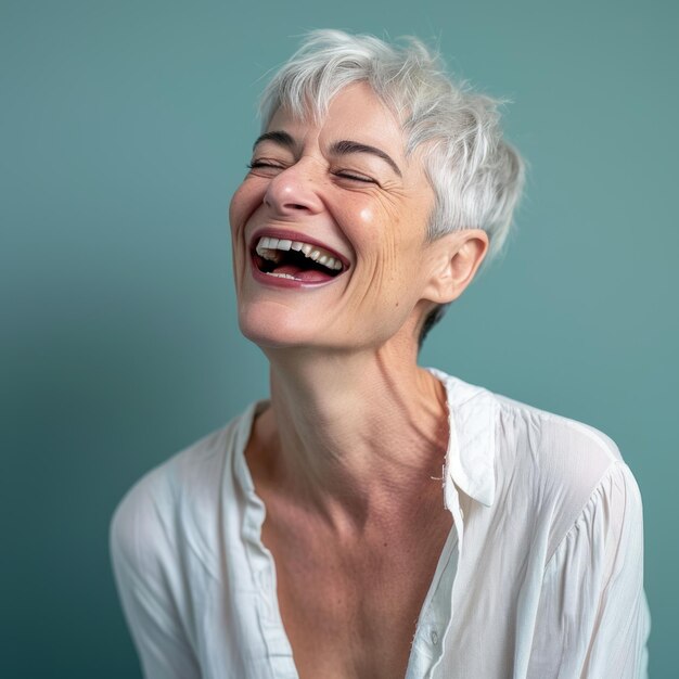 Una mujer con el pelo corto y blanco riendo.