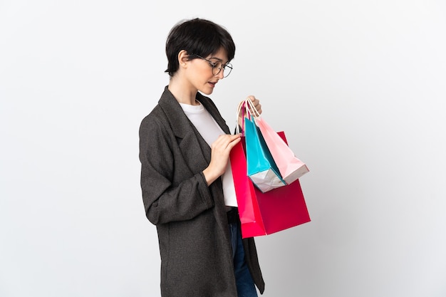 Mujer con pelo corto sosteniendo bolsas de la compra.