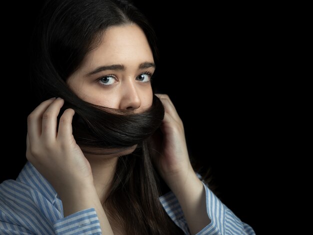 Mujer con el pelo cubriendo su boca. Retrato.