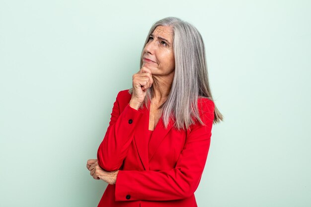 Mujer de pelo gris de mediana edad pensando, sintiéndose dudoso y confundido. concepto de empresaria senior