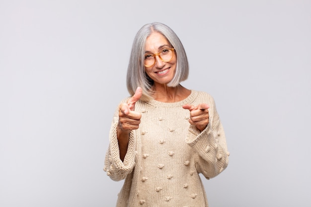 Foto mujer de pelo gris que se siente feliz, fresca, satisfecha, relajada y exitosa, apuntando a la cámara, eligiéndote