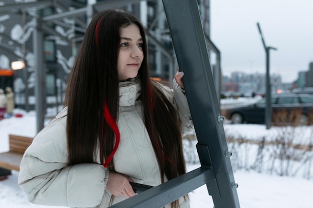 Mujer con el pelo largo y marrón de pie en la nieve