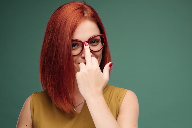 mujer de pelo rojo con maquillaje brillante y gafas