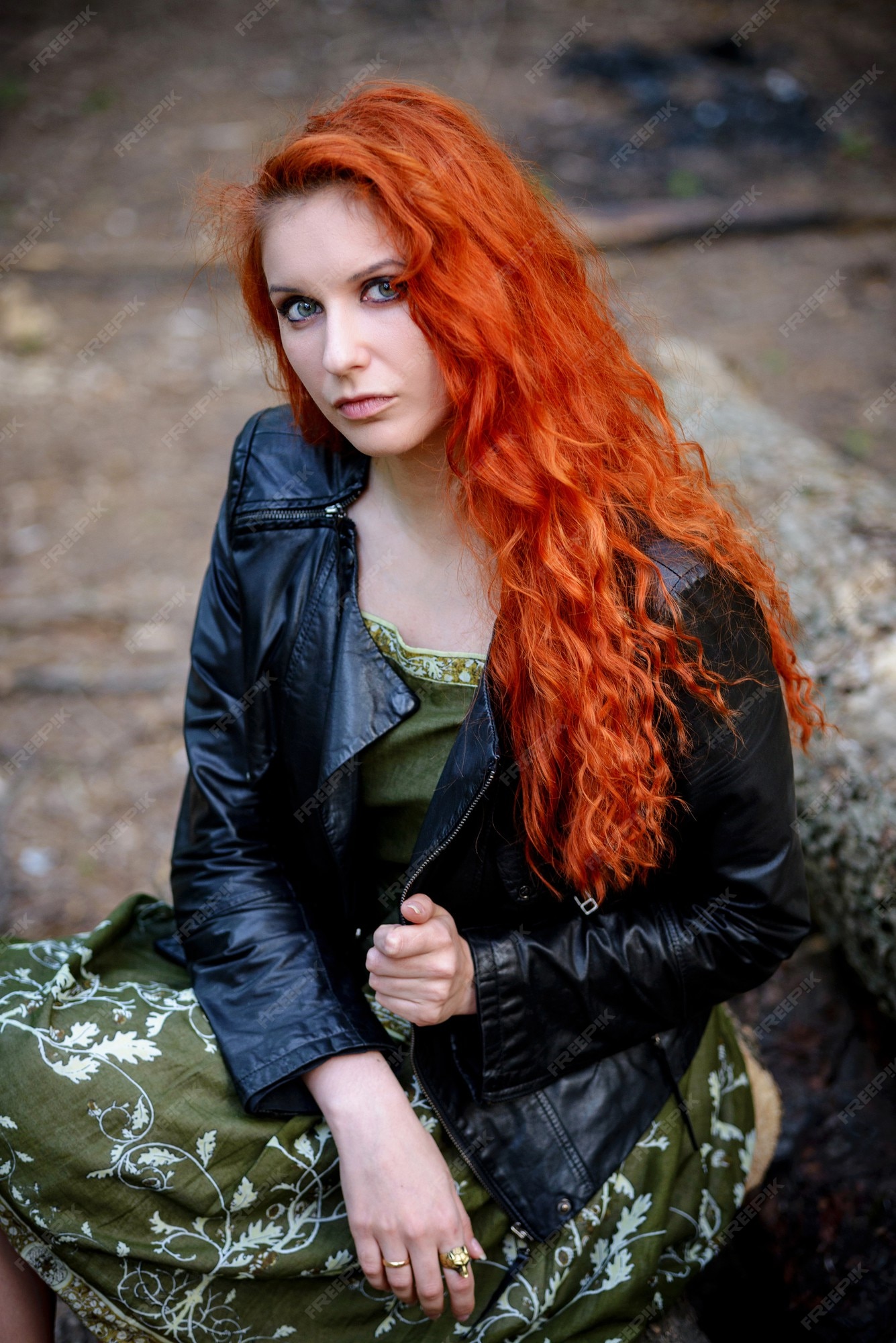 Mujer de rojo sensual de moda sexy bastante joven posando en un fondo de bosque vestida con traje de estilo hipster rock, chaqueta de cuero. | Foto Premium