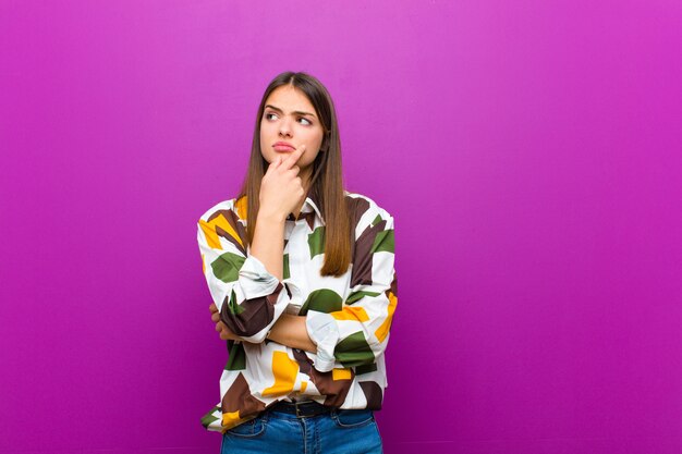 mujer pensando, sintiéndose dudosa y confundida, con diferentes opciones, preguntándose qué decisión tomar