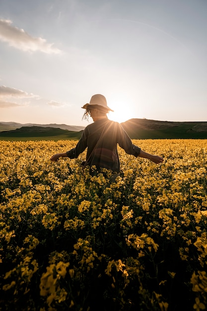 mujer pensativa caminando entre flores en el campo. Concepto de melancolía