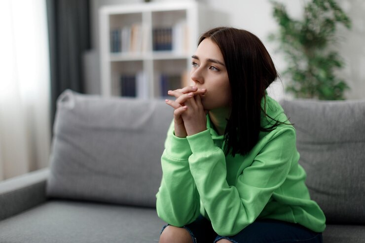 Mujer pensativa en el sofá