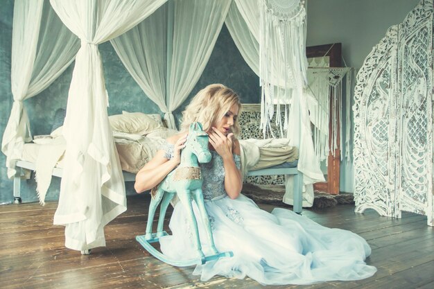 Mujer perfecta con vestido de tul relajante en un romántico interior retro