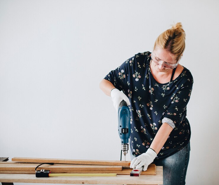 Mujer perforando en un tablón de madera