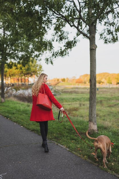 Foto mujer con perro en la carretera contra los árboles