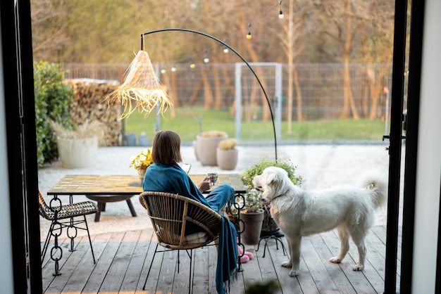 Mujer con perro en casa terraza en el jardín.