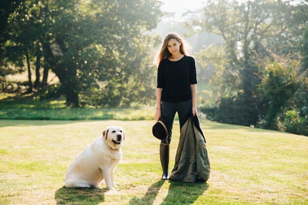 Mujer con perro en césped soleado