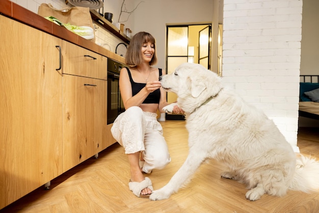 Mujer con perro en la cocina de casa