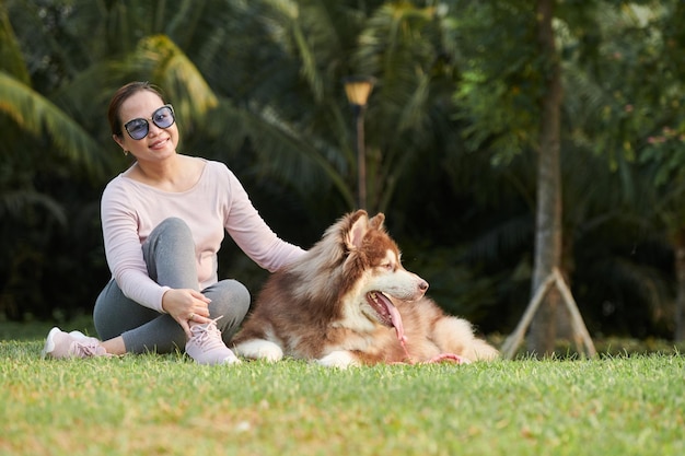 Mujer y perro descansando en el parque