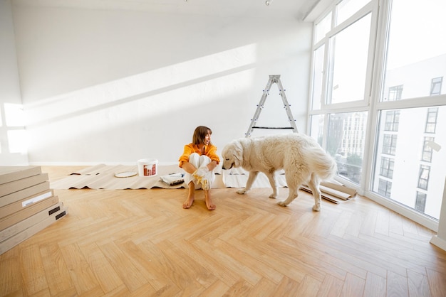 Mujer con perro en la habitación mientras repara en el apartamento