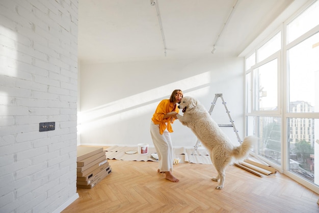 Mujer con perro en la habitación mientras repara en el apartamento