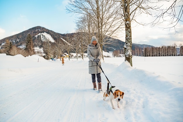 Mujer con perro en un paseo en un paisaje de invierno