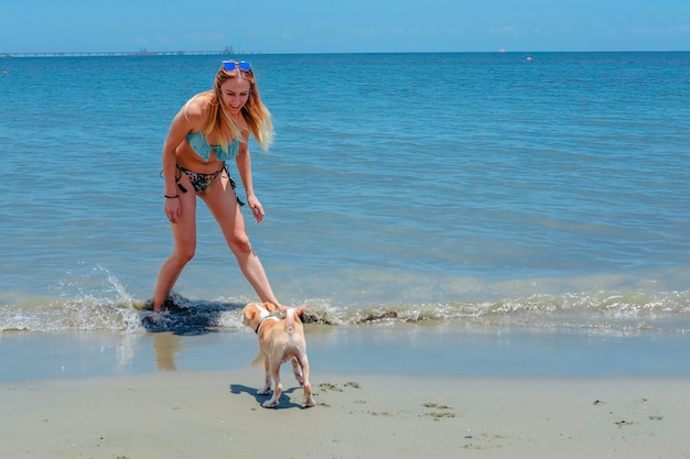 Foto mujer y perro en la playa