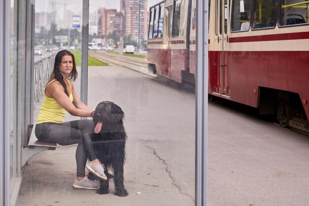 Mujer con perro sentada en la ciudad