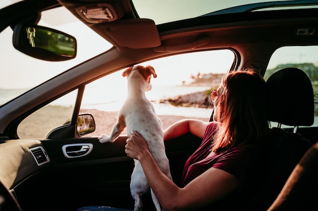 Foto mujer con perro sentada en el coche