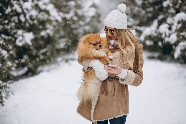 Mujer con perro y teléfono en invierno