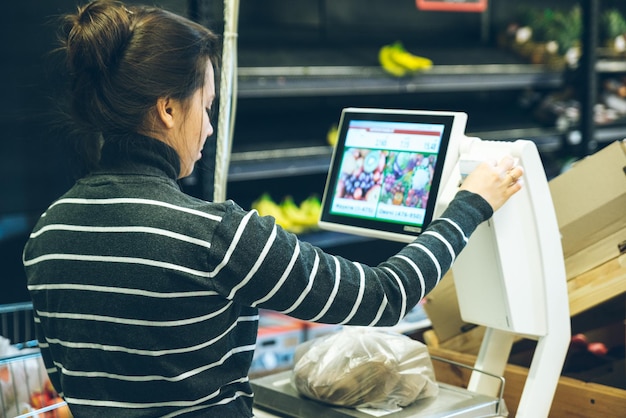 Mujer pesa setas en la tienda