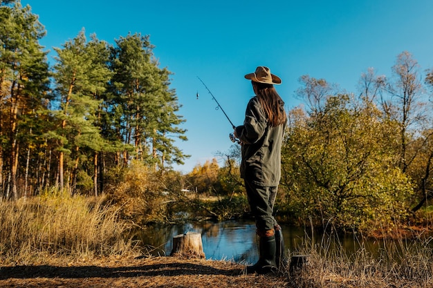 Foto mujer pescando en el río. pesca con caña giratoria.