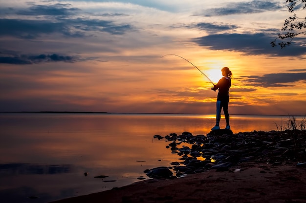 Mujer pescando en spinning de caña de pescar en Finlandia