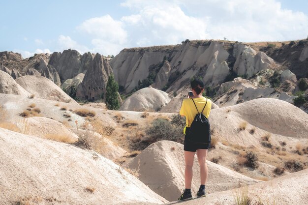 Mujer de pie al revés mientras fotografiaba el paisaje en Capadocia, Turquía