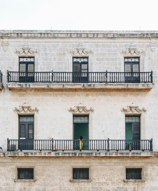 Foto mujer de pie en el balcón del edificio