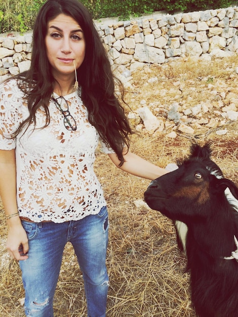 Foto mujer de pie con una cabra