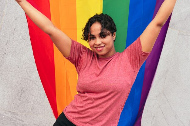 Mujer de pie en la calle con la bandera LGTB. Concepto LGBT