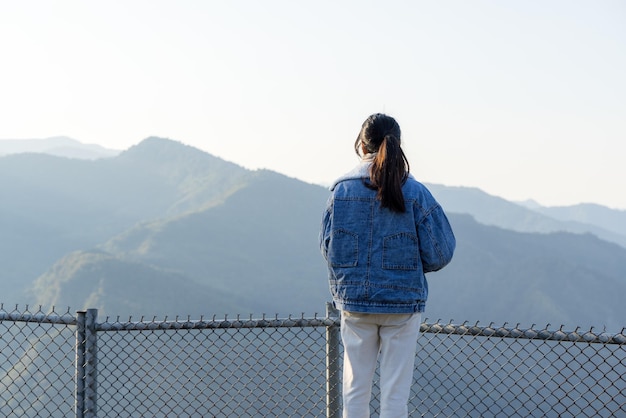 Mujer de pie en la cima de la montaña en el campo