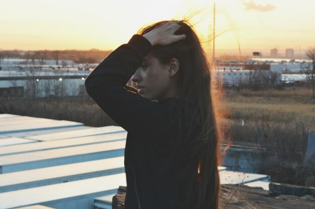 Foto mujer de pie contra el cielo durante la puesta de sol