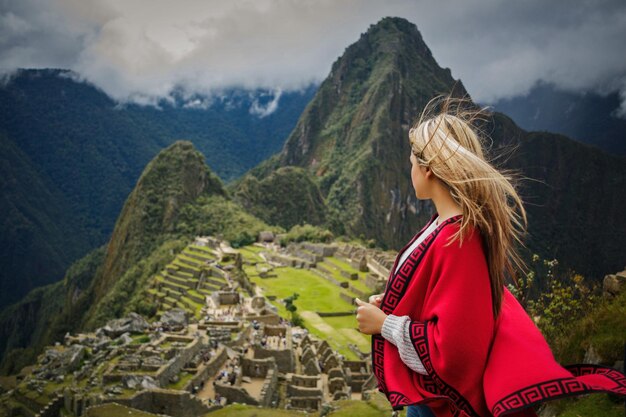 Mujer de pie contra las montañas