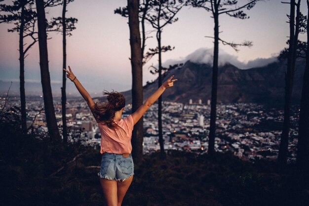 Foto mujer de pie contra el paisaje urbano