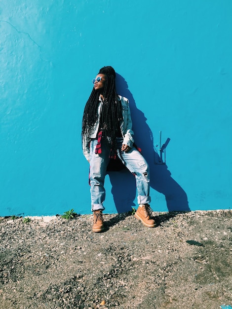Mujer de pie contra la pared azul