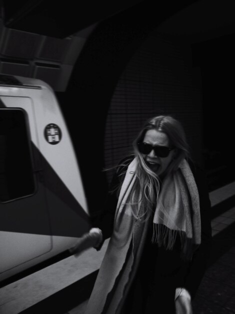 Foto mujer de pie contra el tren del metro