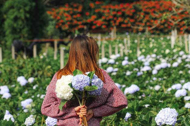 Mujer de pie Dar la vuelta al jardín Flores de hortensia